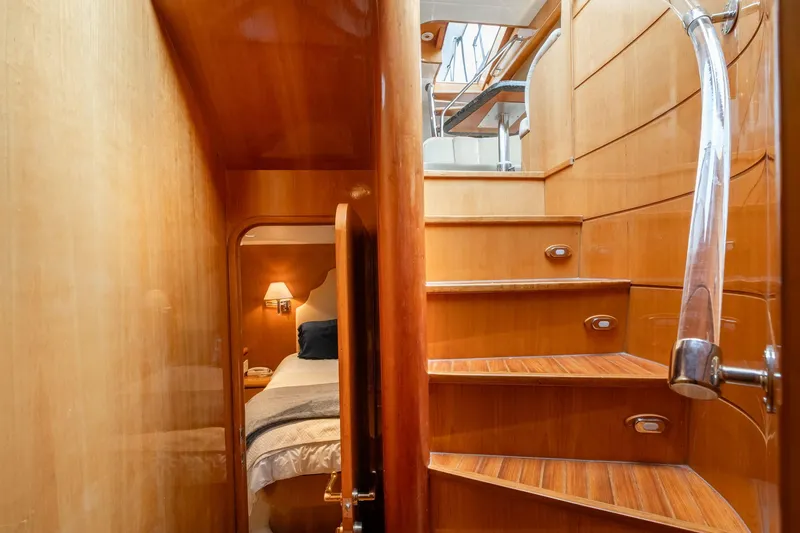 Slide: The Image of Interior of 1999 Vitech 68' Pilothouse yacht with wooden stairs and cozy bedroom. - 43