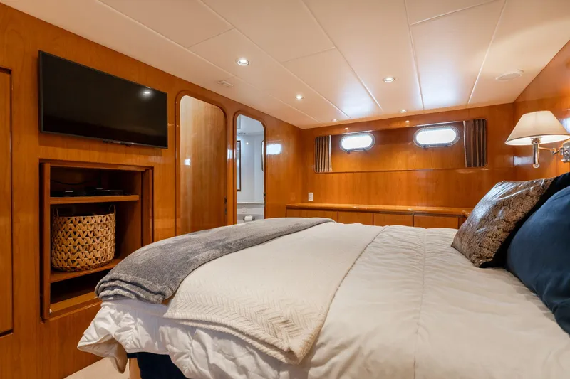 Slide: The Image of Luxurious bedroom in 1999 Vitech 68' Pilothouse yacht with cozy bedding and elegant wood paneling. - 47