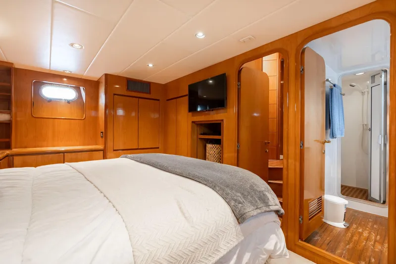 Slide: The Image of Luxurious bedroom in 1999 Vitech 68' Pilothouse yacht with ensuite bathroom and wooden accents. - 49