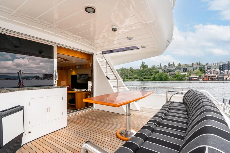 Slide: The Image of Luxurious 1999 Vitech 68' Pilothouse yacht deck with seating, table, and waterfront view. - 7