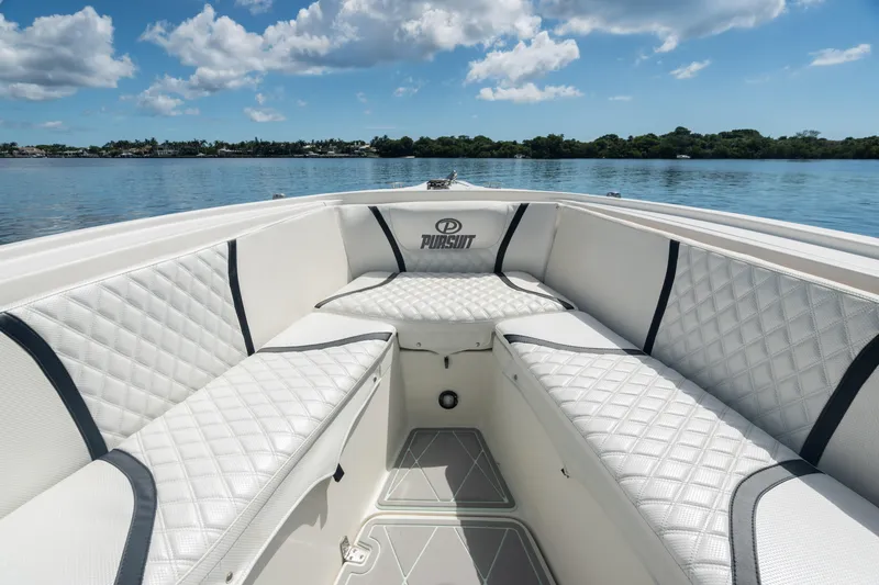 Slide: The Image of 2000 Pursuit 2870 Center Console boat with white cushioned seating on calm water. - 10