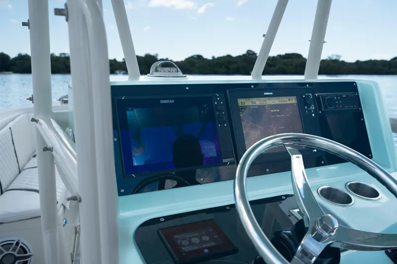 Slide: The Image of 2000 Pursuit 2870 Center Console boat dashboard with navigation screens and steering wheel. - 15
