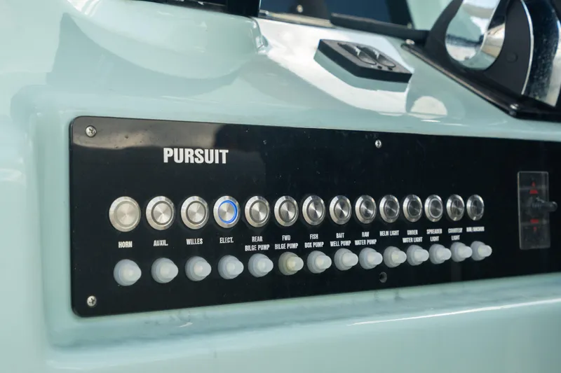 Slide: The Image of Control panel of a 2000 Pursuit 2870 Center Console boat with labeled switches. - 16