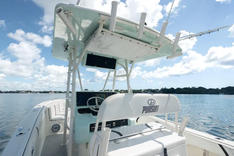 Slide: The Image of 2000 Pursuit 2870 Center Console boat on a calm lake under a blue sky. - 18