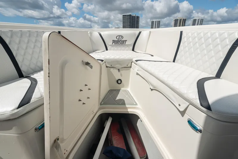 Slide: The Image of 2000 Pursuit 2870 Center Console boat with open storage compartment and cushioned seating. - 19