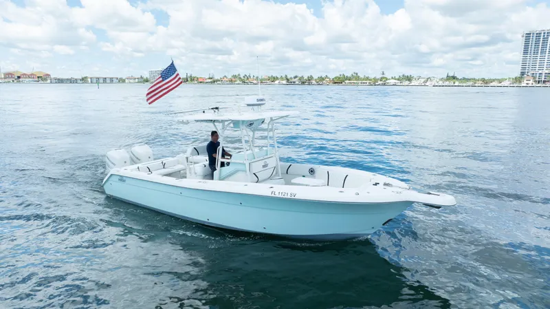 Slide: The Image of 2000 Pursuit 2870 Center Console boat on water with American flag. - 2