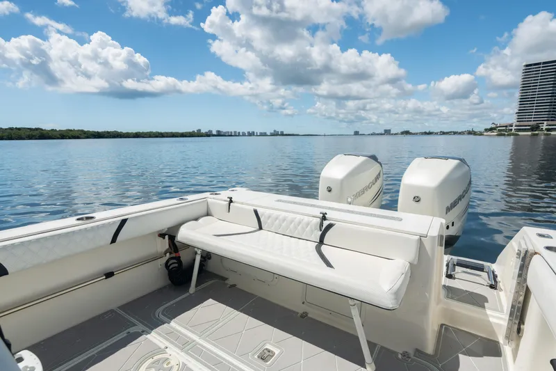 Slide: The Image of 2000 Pursuit 2870 Center Console boat with twin outboard engines on a calm lake. - 24