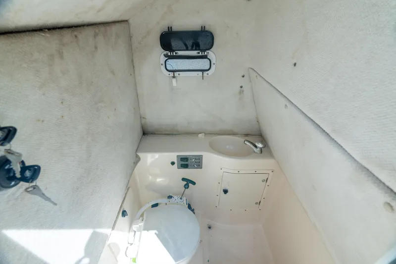 Slide: The Image of 2000 Pursuit 2870 Center Console boat interior cabin with toilet and sink. - 28