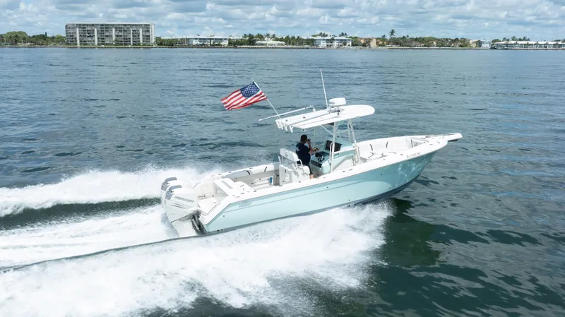Slide: The Image of 2000 Pursuit 2870 Center Console boat cruising on water with American flag. - 7