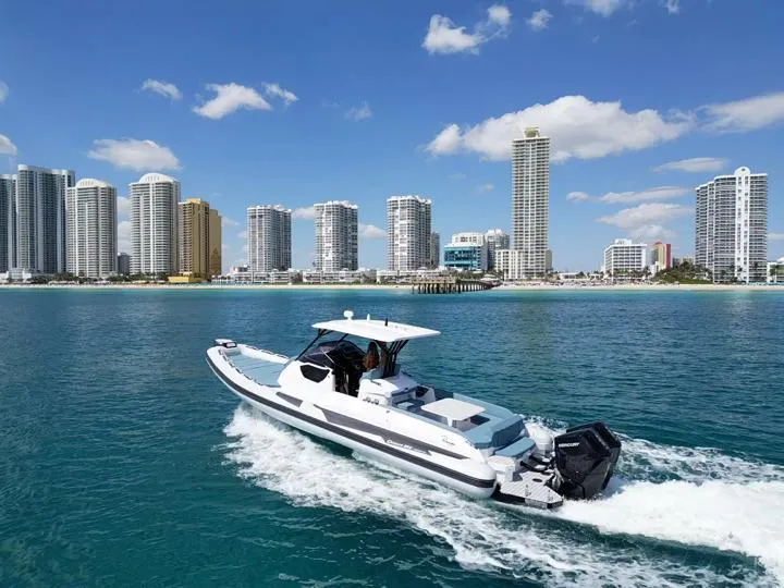 Slide: The Image of Ranieri CAYMAN 38.0 EXECUTIVE 2025 cruising near a city skyline on a sunny day. - 4