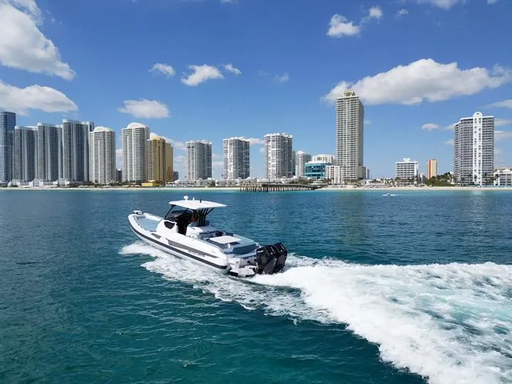 Slide: The Image of Ranieri CAYMAN 38.0 EXECUTIVE 2025 cruising near a city skyline on a sunny day. - 9