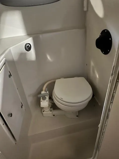 Slide: The Image of 1999 Four Winns 258 Vista boat bathroom with toilet and storage cabinet. - 10