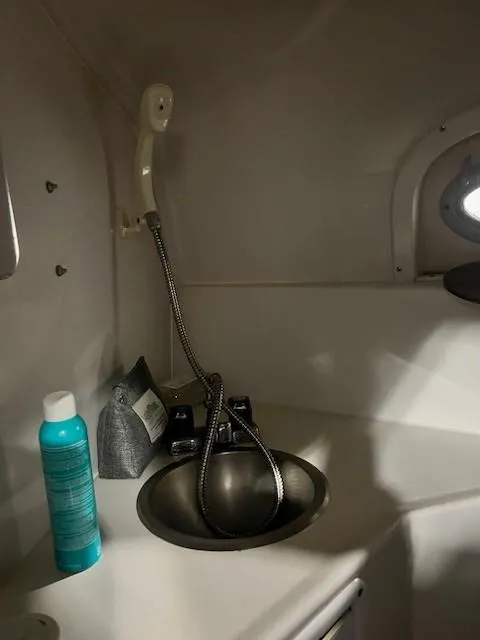 Slide: The Image of 1999 Four Winns 258 Vista boat interior sink with faucet and toiletries. - 11