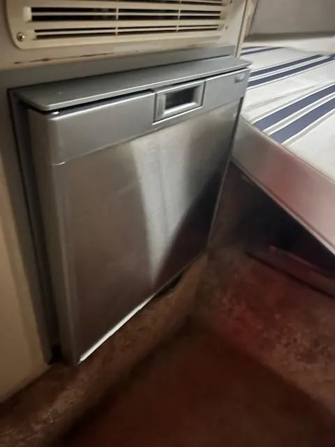 Slide: The Image of 1999 Four Winns 258 Vista boat interior with built-in refrigerator. - 9