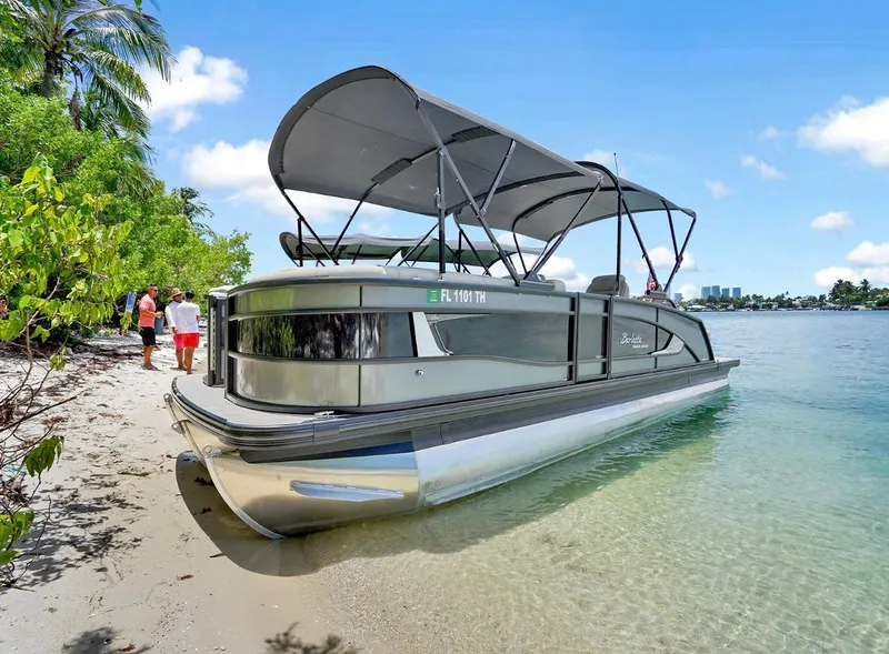 Slide: The Image of 2022 Barletta Lusso 25UC pontoon boat docked on a sandy beach. - 1
