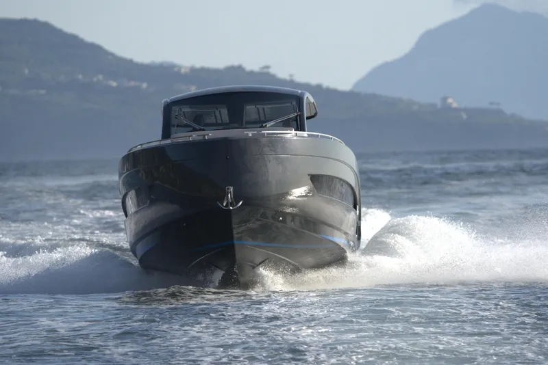 Slide: The Image of Nassima Yacht N40 2025 cruising on water with mountainous background. - 2