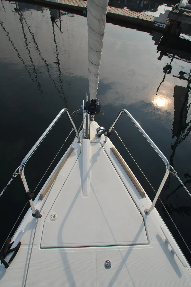Slide: The Image of Bow view of 2015 Jeanneau 349 sailboat reflecting on calm water. - 11