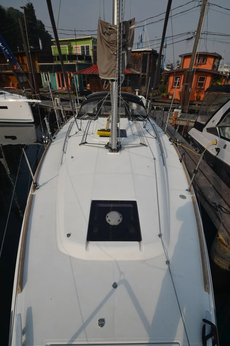 Slide: The Image of 2015 Jeanneau 349 sailboat docked, showcasing sleek deck design and vibrant marina backdrop. - 12