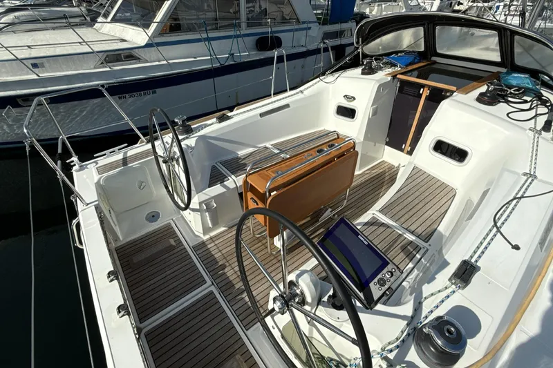 Slide: The Image of 2015 Jeanneau 349 sailboat cockpit with dual steering wheels and navigation equipment. - 15