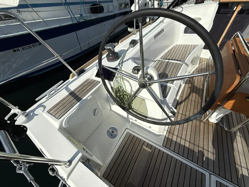Slide: The Image of 2015 Jeanneau 349 sailboat cockpit with steering wheel and teak flooring. - 17