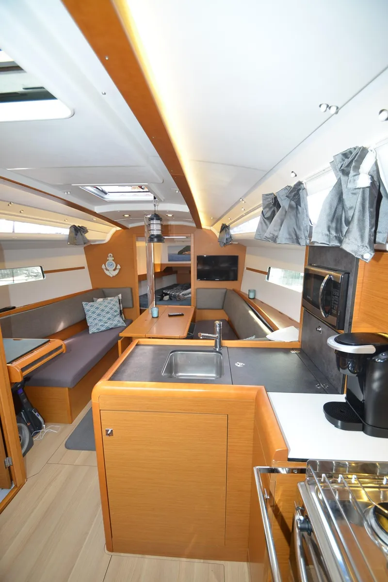 Slide: The Image of Interior of 2015 Jeanneau 349 sailboat with modern kitchen and seating area. - 21
