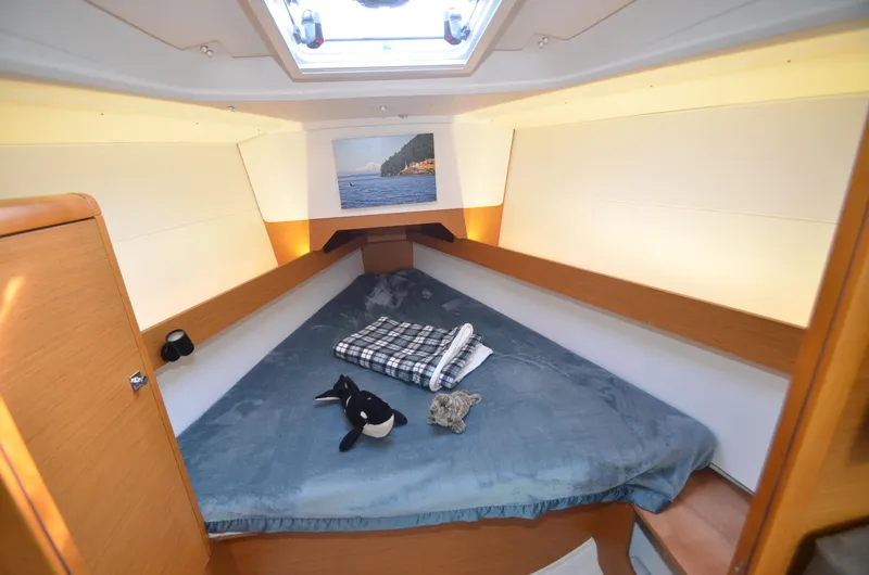 Slide: The Image of 2015 Jeanneau 349 cabin with cozy bed, skylight, and nautical decor. - 22