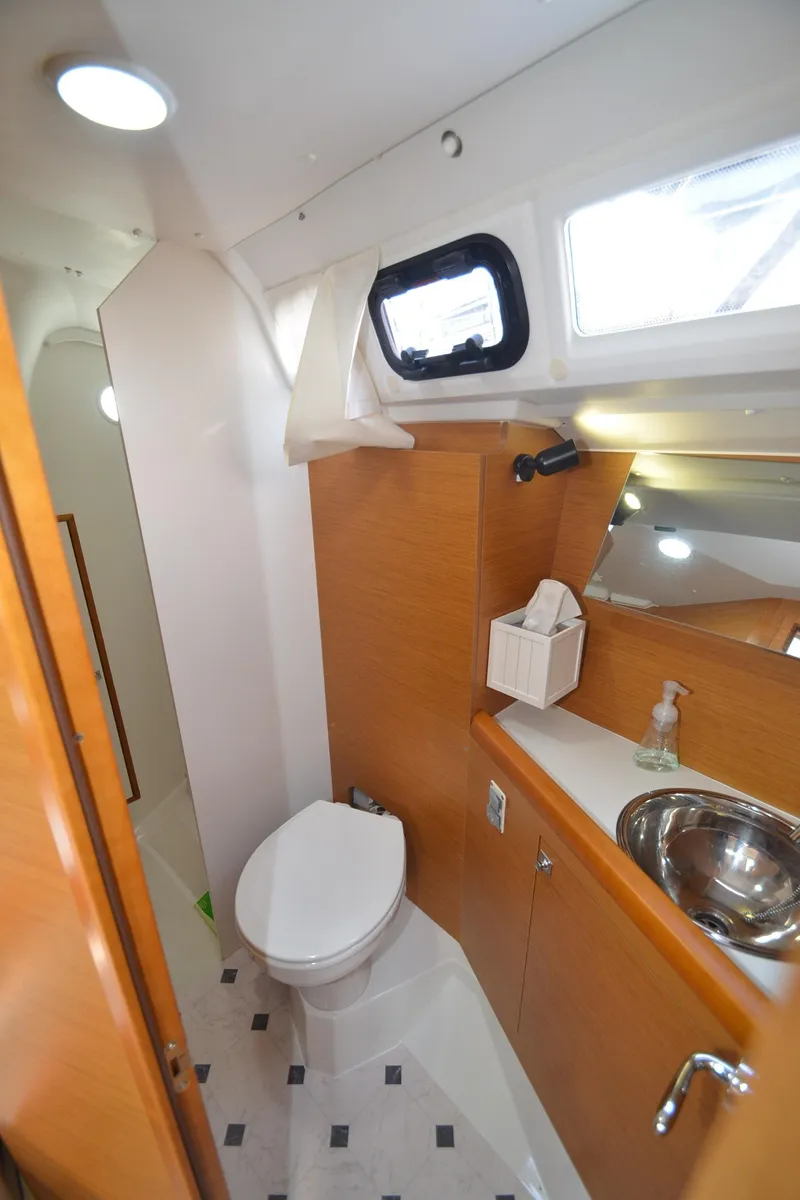 Slide: The Image of 2015 Jeanneau 349 yacht bathroom with modern fixtures and wooden cabinetry. - 25
