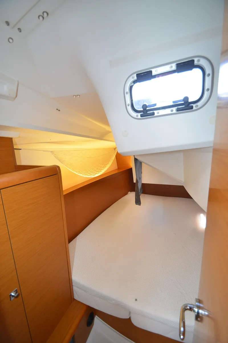 Slide: The Image of 2015 Jeanneau 349 cabin interior with porthole and wooden cabinetry. - 28