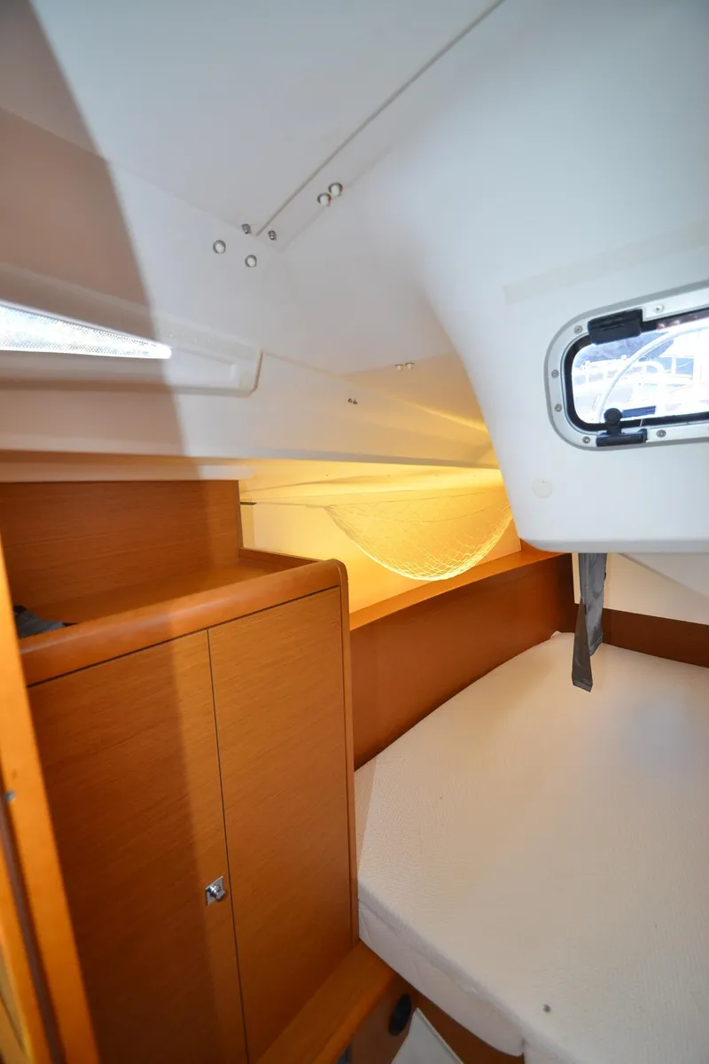 Slide: The Image of Interior cabin of 2015 Jeanneau 349 sailboat, featuring wooden cabinetry and a cozy sleeping area. - 29