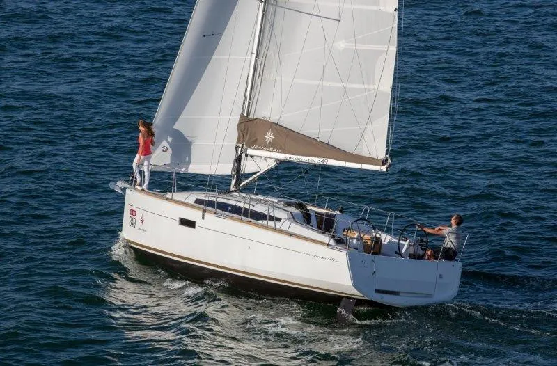 Slide: The Image of 2015 Jeanneau 349 sailboat navigating open waters with two people on board. - 35