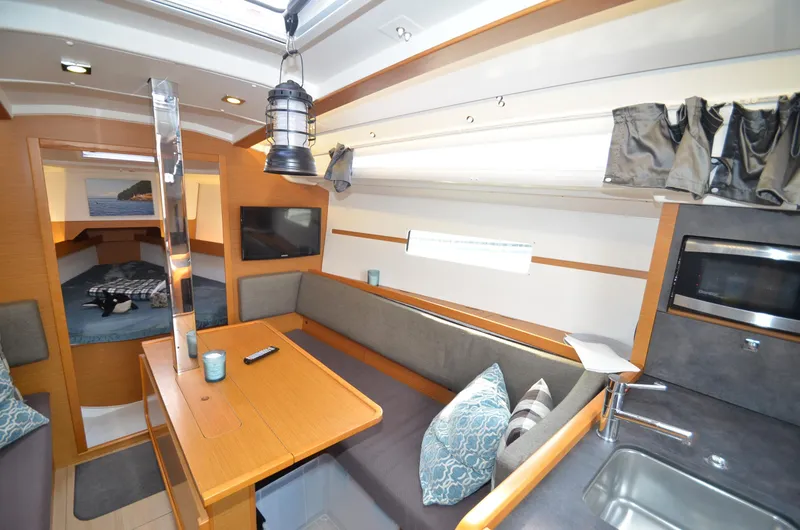 Slide: The Image of Interior of 2015 Jeanneau 349 sailboat with cozy seating, table, and modern amenities. - 6