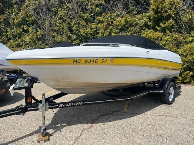Slide: The Image of 2003 Four Winns 180 Freedom I/O boat on trailer with cover. - 2