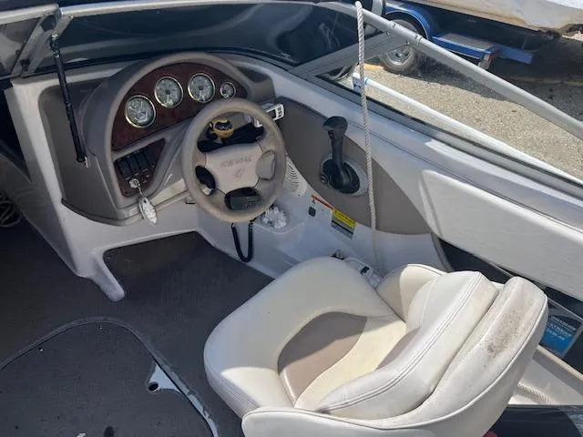 Slide: The Image of 2003 Four Winns 180 Freedom I/O boat cockpit with steering wheel and control panel. - 4