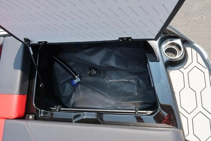 Slide: The Image of 2025 MasterCraft NXT20 storage compartment with hydraulic lift and cup holder. - 16