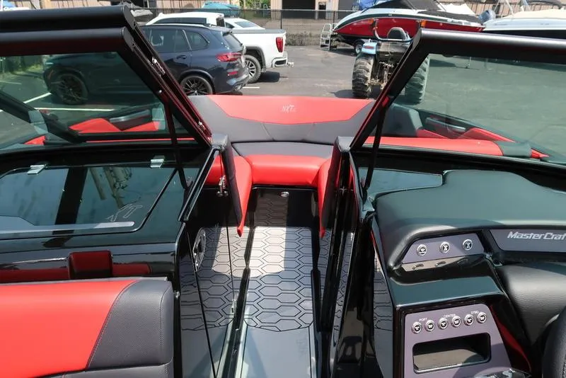 Slide: The Image of 2025 MasterCraft NXT20 interior with red and black seating, open windshield, and modern dashboard. - 26