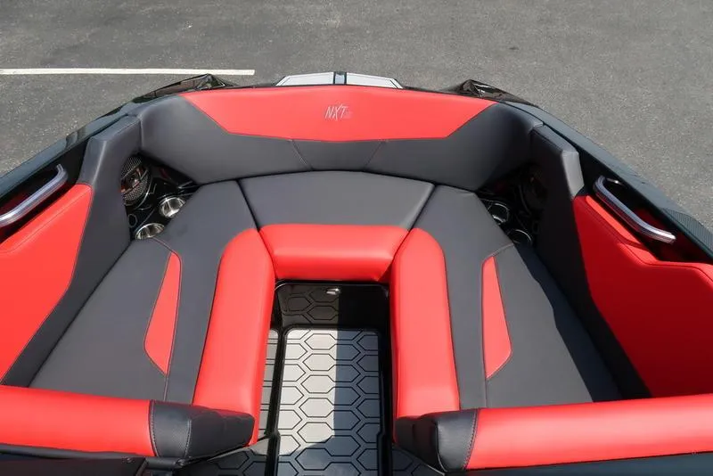 Slide: The Image of 2025 MasterCraft NXT20 boat interior with red and gray seating, hexagonal floor pattern. - 27