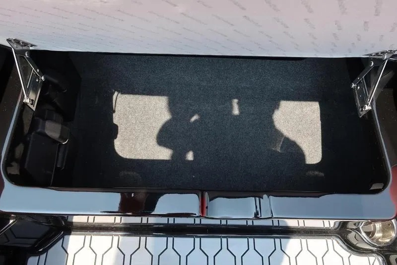 Slide: The Image of Open storage compartment in 2025 MasterCraft NXT20 boat, featuring carpeted interior and sleek design. - 28