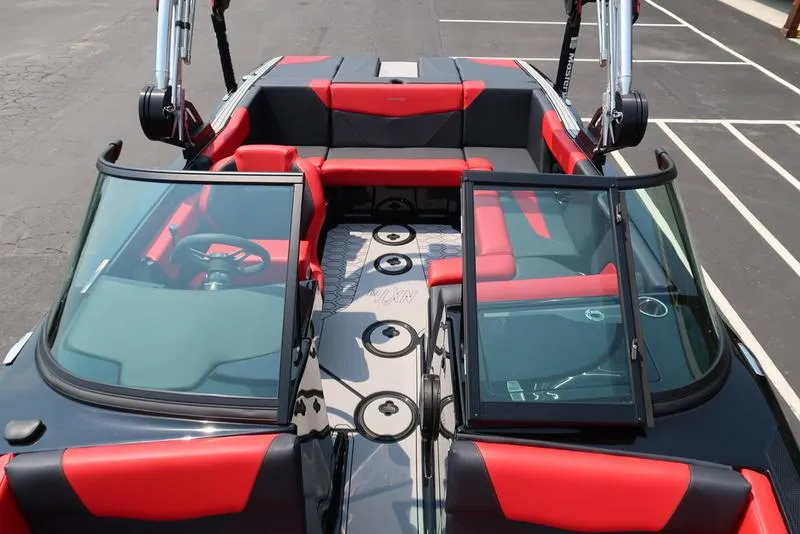 Slide: The Image of 2025 MasterCraft NXT20 boat interior with red and black seating, open windshield, and cup holders. - 34