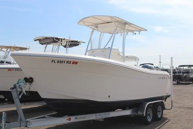 The Image of 2019 Cobia 220CC boat on a trailer in a parking lot. - 1
