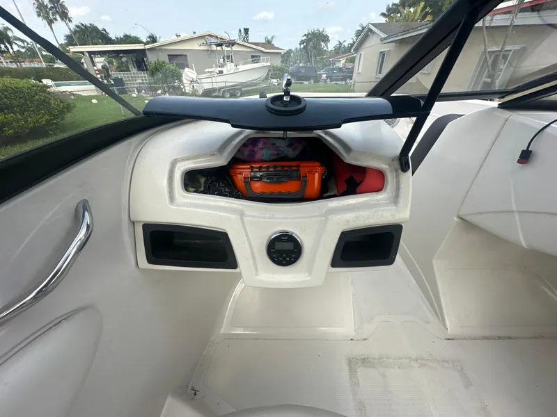 Slide: The Image of 2016 Tahoe 550 TS boat dashboard with storage compartments and safety equipment. - 10