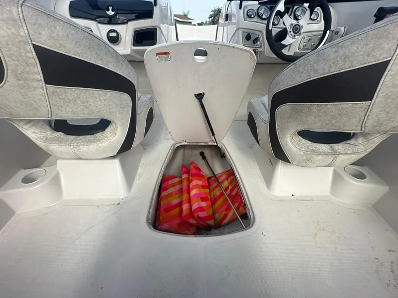 Slide: The Image of 2016 Tahoe 550 TS boat interior with open storage compartment and life jackets. - 14