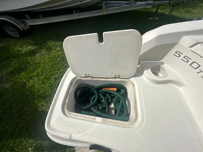 Slide: The Image of Open storage compartment on a 2016 Tahoe 550 TS boat with coiled rope inside. - 18