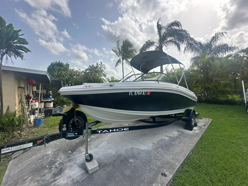Slide: The Image of 2016 Tahoe 550 TS boat on trailer, parked in a tropical backyard. - 6