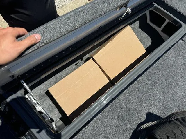Slide: The Image of Storage compartment of 2025 Phoenix Bass Boats 721 ZXL with cardboard boxes. - 25