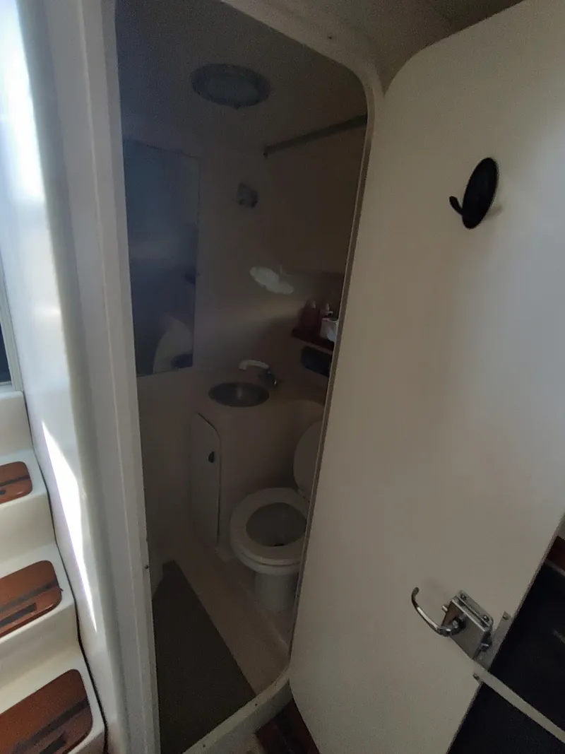 Slide: The Image of 1994 Tiara Yachts 3100 Open boat bathroom with toilet and sink. - 11