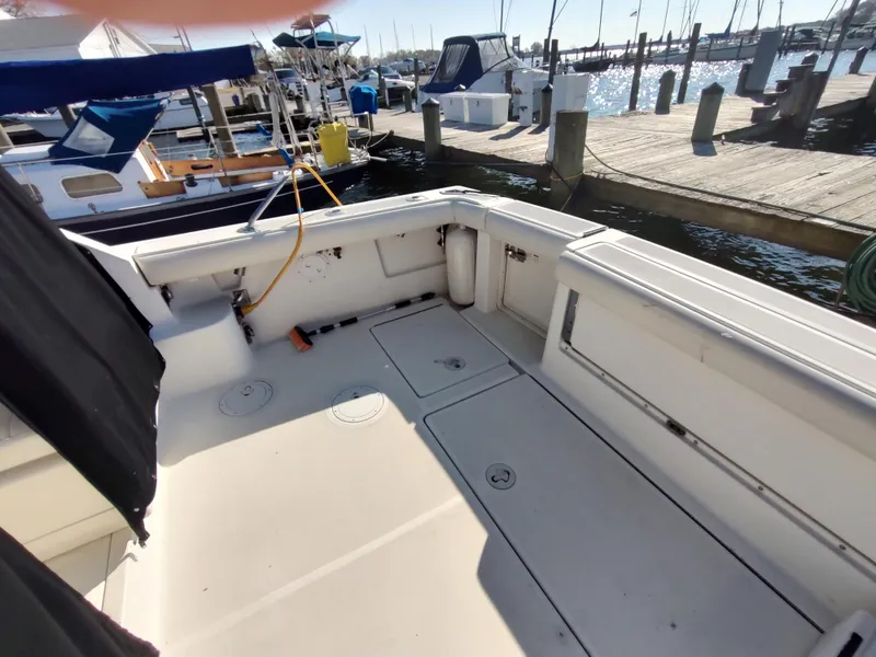 Slide: The Image of 1994 Tiara Yachts 3100 Open boat deck at marina with docked boats. - 2