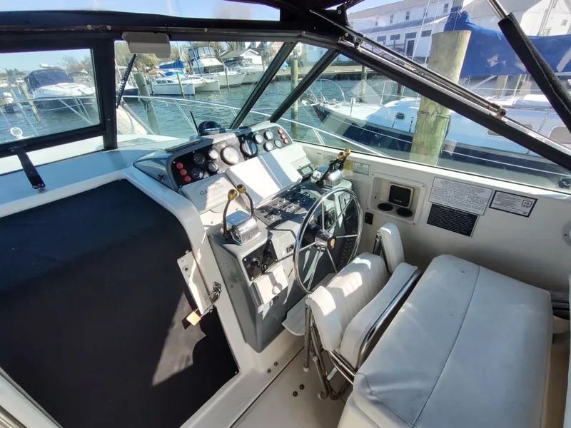 Slide: The Image of 1994 Tiara Yachts 3100 Open helm with Garmin navigation, docked at marina. - 3