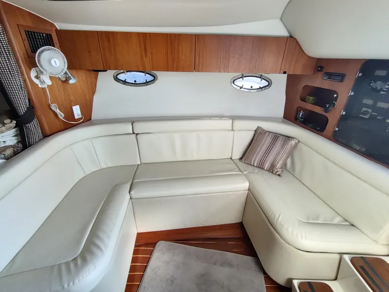 Slide: The Image of 1994 Tiara Yachts 3100 Open interior with white leather seating and wooden cabinetry. - 6