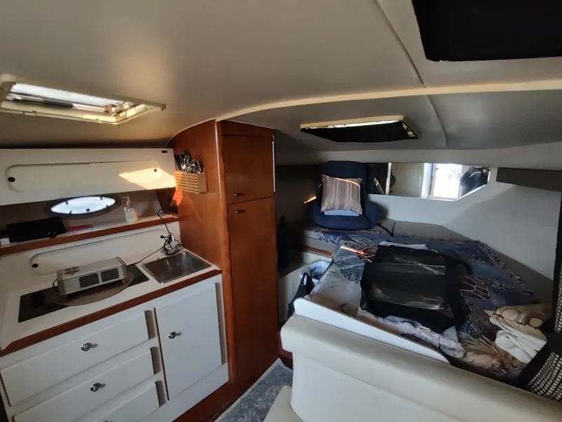 Slide: The Image of 1994 Tiara Yachts 3100 Open cabin interior with kitchenette and sleeping area. - 8