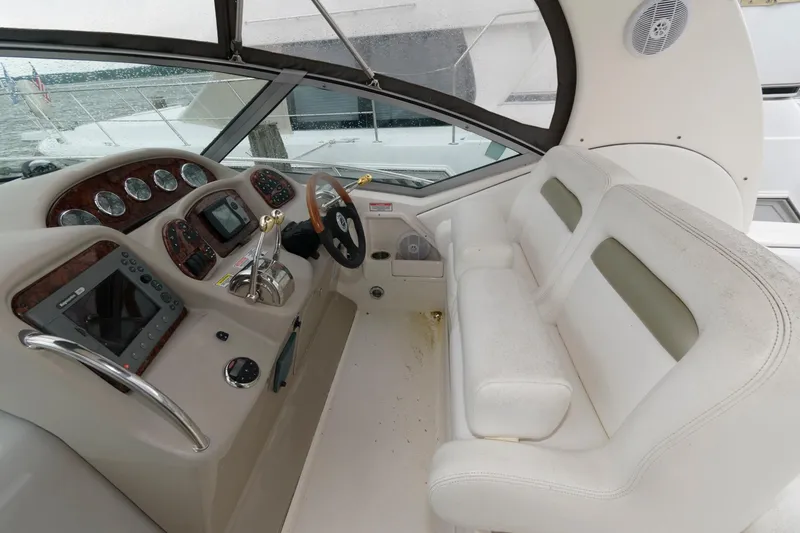 Slide: The Image of 2006 Sea Ray 320 Sundancer helm with white seating and control panel. - 8